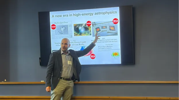 Photo of Professor Lorenzo Sironi explaining cosmic ray particles